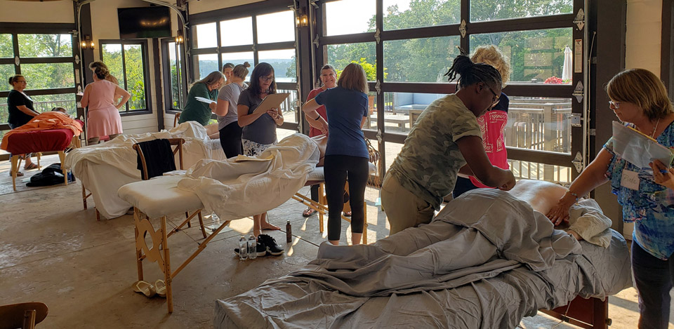 CARE Instructors checking each other's Raindrop and Vitaflex skills at CCI Summit